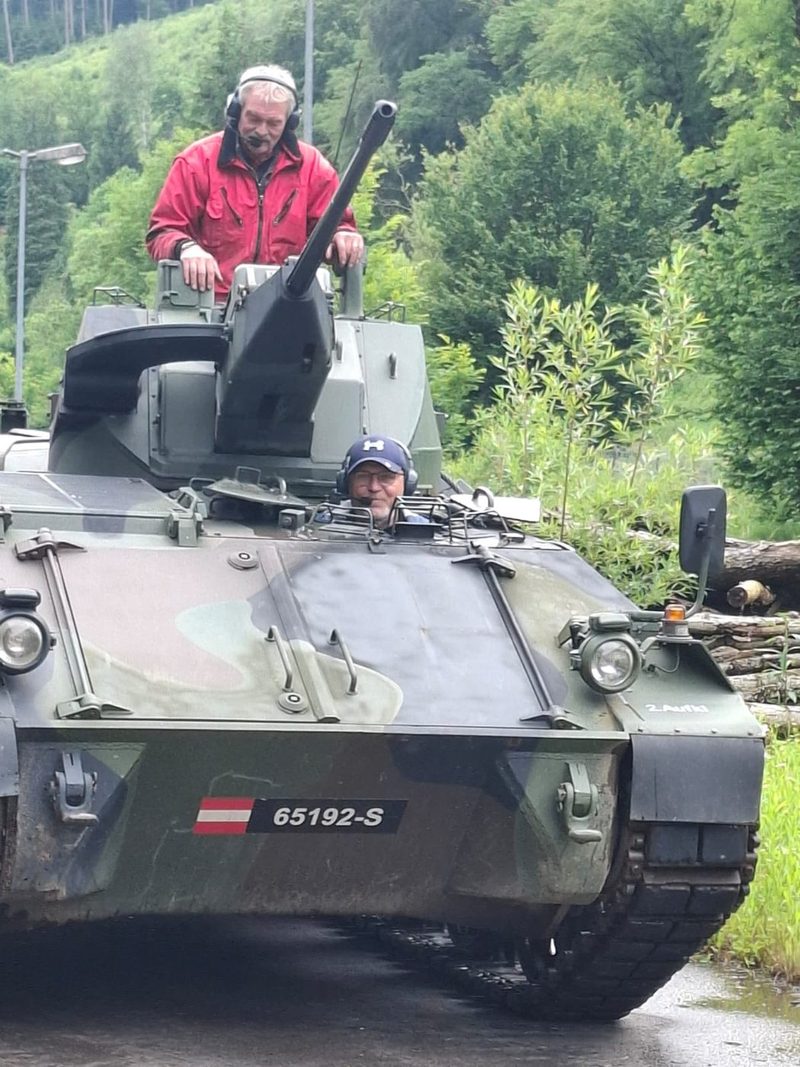 Gast steht im Turm des Kettenpanzers, ein weiterer sitzt am Fahrerplatz