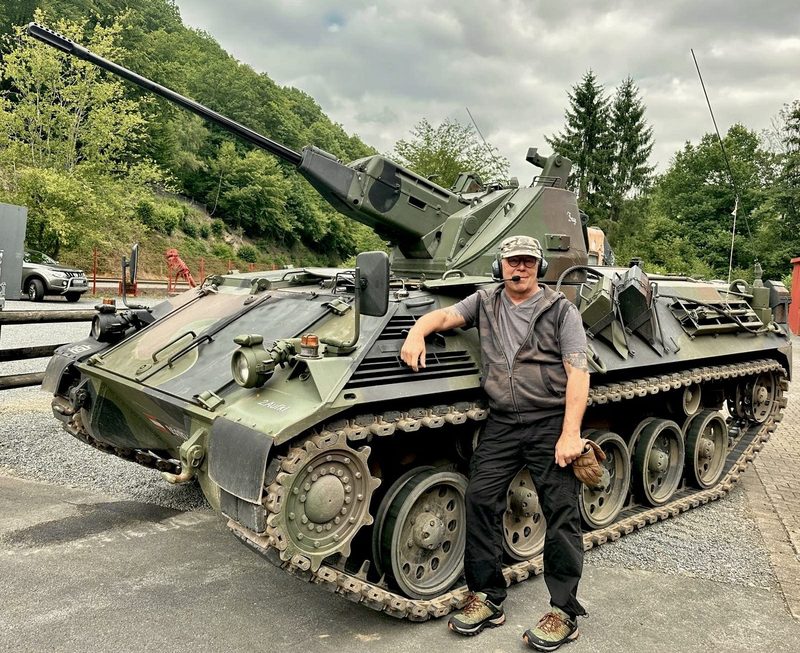 Gast neben dem Kettenpanzer nach der Fahrt