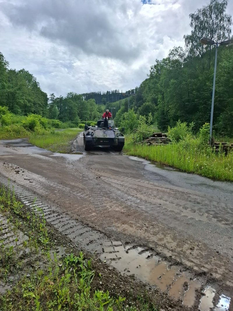Kettenpanzer kommt auf regennasser Strecke entgegen