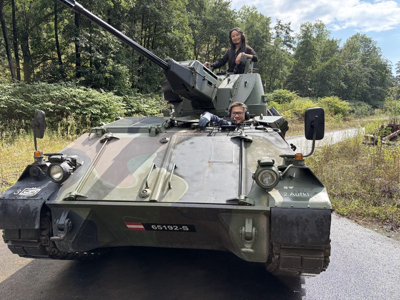 Zwei Gäste auf dem Kettenpanzer, von vorn aufgenommen
